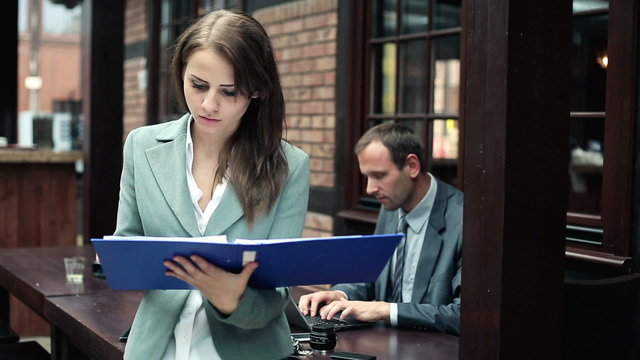 Young pretty businesswoman reading documents in the office