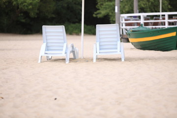 white pool chairs on sand beach