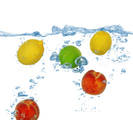 Tropical fruits falling into water with splash isolated on