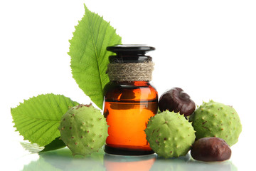 medicine bottle with chestnuts and leaves, isolated on white