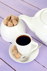 Cup of coffee, teapot and sugar-bowl on color wooden background