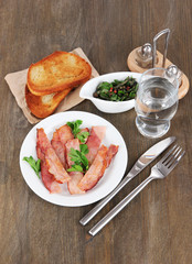 Bacon on plates on wooden table