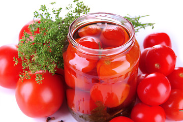 Open glass jar of tasty canned tomatoes, isolated on white