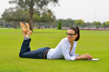 Fototapeta premium Beautiful young woman with tablet in park