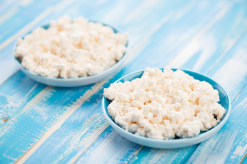 Two saucers with fresh cottage cheese, horizontal shot