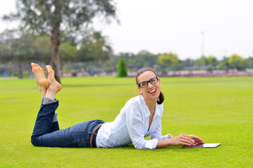Fototapeta premium Beautiful young woman with tablet in park