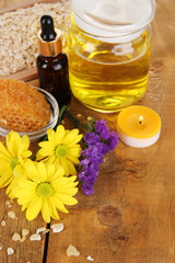 Fototapeta na wymiar Fragrant honey spa with oils and honey on wooden table close-up