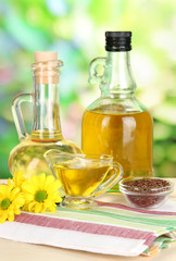Useful linseed oil on wooden table on natural background