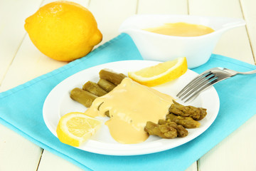 Asparagus on plate, on wooden background