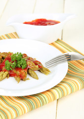 Asparagus on plate, on wooden table on bright background