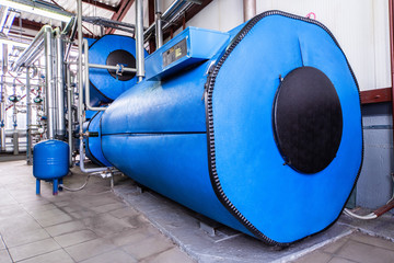 Big blue reservoirs in factory boiler room