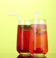 Two cherry cocktails with ice on green background