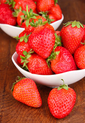 Fresh strawberry in bowl on wooden background