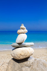 Pebbles stack balance over blue ionian sea