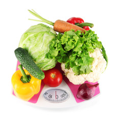 Fresh vegetables on scales on grey background