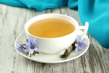 Cup of tea with chicory, on wooden background