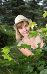 The girl looks out because of a bush