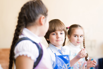 boy draws in class with other children