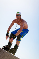 junger sportlicher mann mit inline skates im sommer