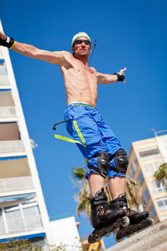 junger sportlicher mann mit inline skates im sommer