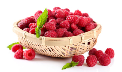 Ripe sweet raspberries in basket, isolated on white