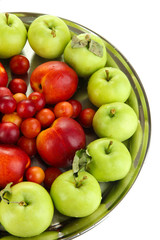 Assortment of juicy fruits on plate, isolated on white
