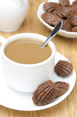 chocolate cookies madeleine, cup of coffee with milk, vertical