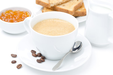 Close-up of cappuccino, milk, fresh toast and jam on a white