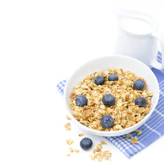 muesli with blueberries and jug of milk, isolated