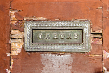 old mail slot in a wooden door