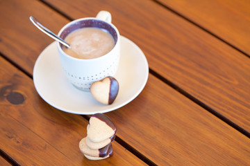 Stacked heart shaped cookies and cup of coffee, copyspace