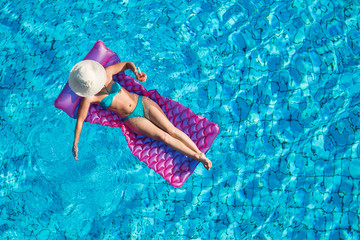 Junge Frau auf der Luftmatratze im Pool