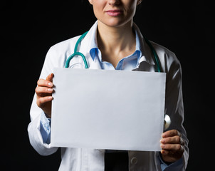 Closeup on doctor woman showing blank paper sheet isolated
