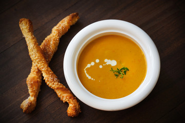 Creamy soup of carrots, potatoes, thyme and sesame breadsticks