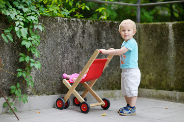 Cute little boy with his toy carriage