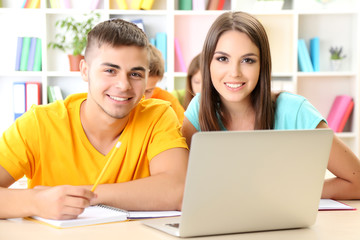 Group of young students sitting at the library