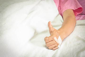Hand of man with drip in hospital bed