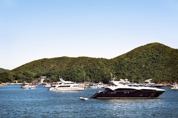 Fototapeta na wymiar Luxury boats anchored in a bay off Hong Kong Island