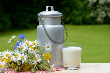 Kanne mit Milch und Blumen