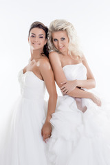 Fototapeta na wymiar Smiling young girls posing in wedding dresses