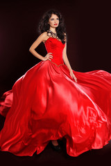 Beautiful woman in red dress isolated on black background. Studi