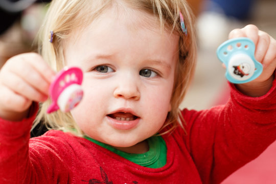 Kind spielt mit Schnullern