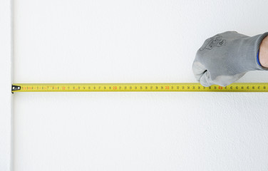 Hand in protective gloves with Metre measure ruler