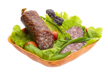 Ripe salami with salad, basil, onion and tomato