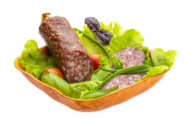 Ripe salami with salad, basil, onion and tomato