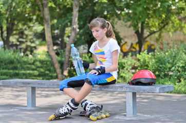 Teenage girl drinking water during skating break