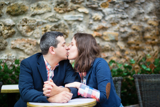 Couple kissing in an outdoor cafe
