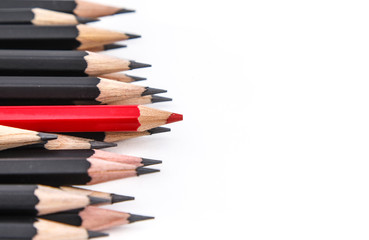 Fototapeta premium A red pencil against black pencil