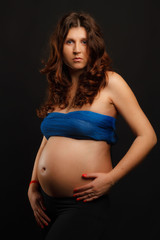 Pregnant woman portrait over dark background