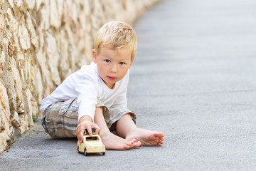Three year old boy playing with car